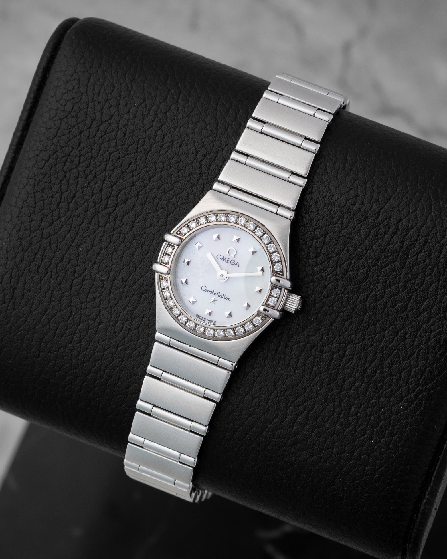 Angled view of the ladies Omega Constellation reference 1465.71.00 26mm showing the mother of pearl dial, iconic claws, and stainless steel integrated bracelet.
