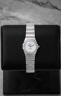 Omega Constellation 1465.71.00 26mm luxury watch in stainless steel, featuring a white mother of pearl dial and factory diamond bezel, displayed on a black cushion.
