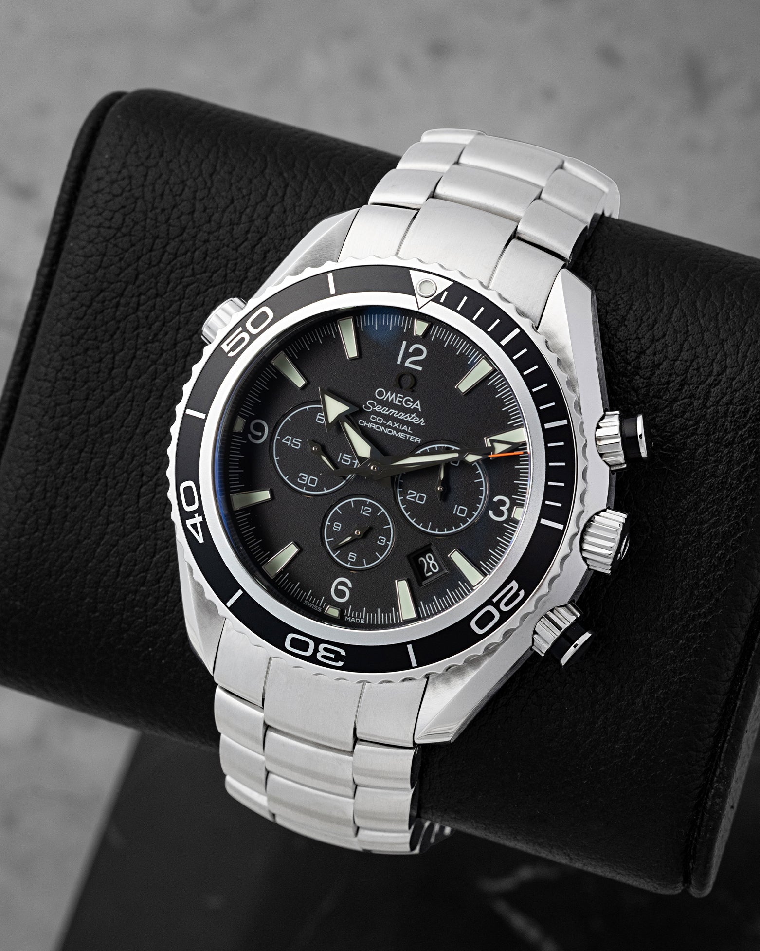 Angled view of Omega Planet Ocean 2210.50.00 displaying black chronograph sub-dials, orange accents, and black bezel
