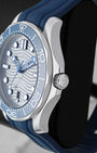 Right side profile view highlighting the stainless steel case finish, screw-down crown, and blue ceramic unidirectional rotating bezel of an Omega Seamaster Diver 300M