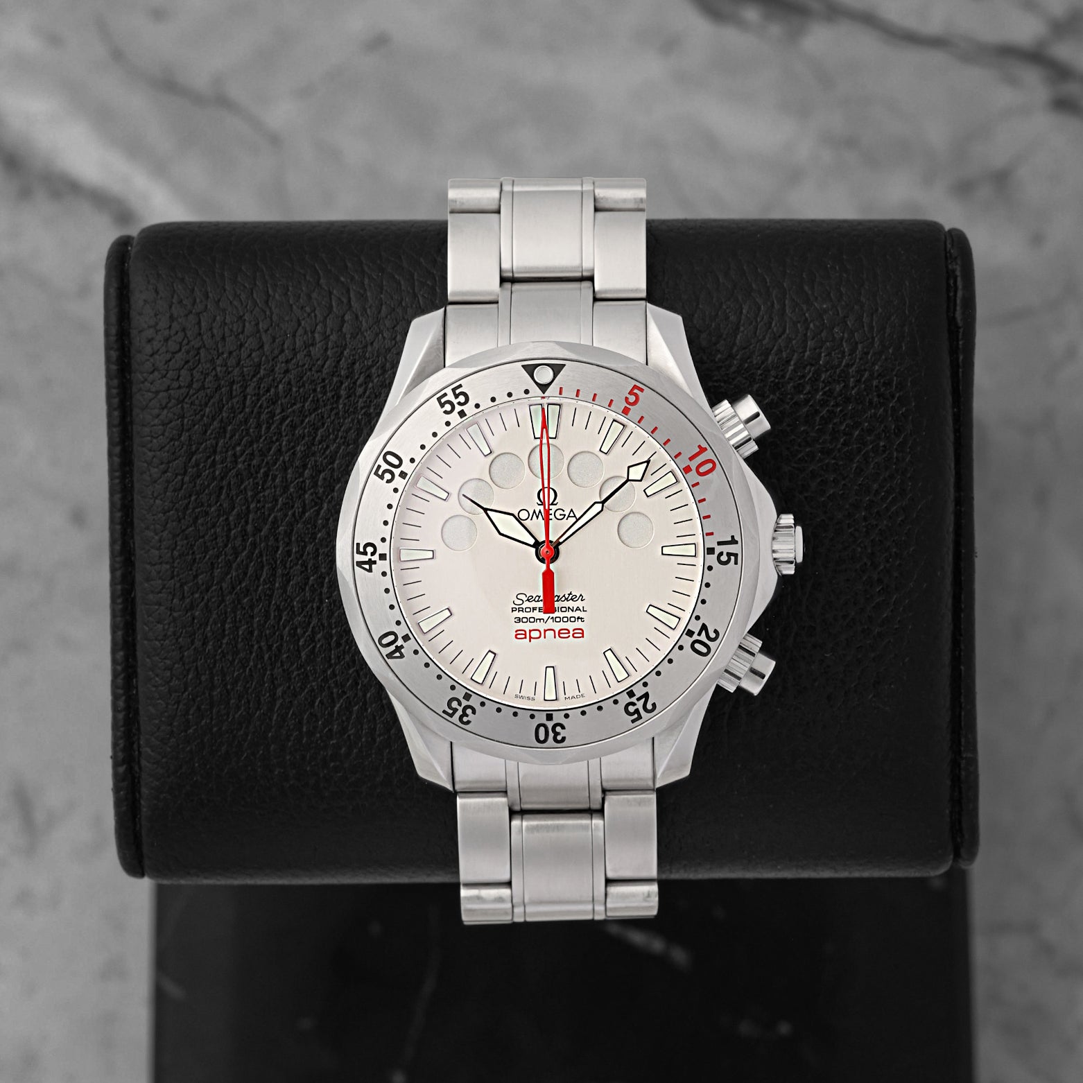 An Omega Seamaster Apnea Jacques Mayol reference 2595.30.00 displaying its silver dial with seven circular free-diving minute timing apertures and a red chronograph hand at Noah's Fine Watches & Jewelry in Dallas