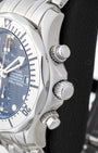 Side profile view of the stainless steel case showing the scalloped bezel, main crown, and screw-down chronograph pushers