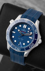 Angled view of a 2024 Omega Seamaster Diver 300M Co-Axial Master Chronometer 42mm watch on a matching blue rubber strap.