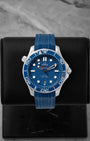 2024 Omega Seamaster Diver 300M reference 210.32.42.20.03.001 featuring a blue ceramic laser-engraved wave dial, ceramic bezel, and blue rubber strap.