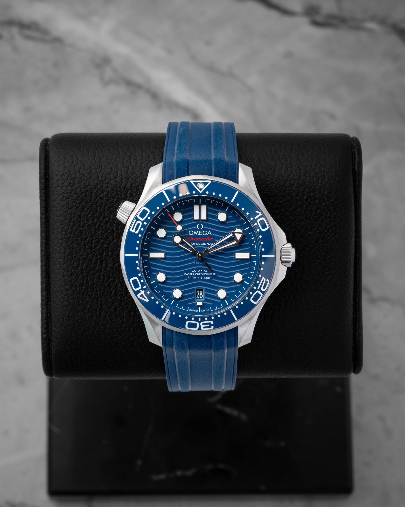 2024 Omega Seamaster Diver 300M reference 210.32.42.20.03.001 featuring a blue ceramic laser-engraved wave dial, ceramic bezel, and blue rubber strap.