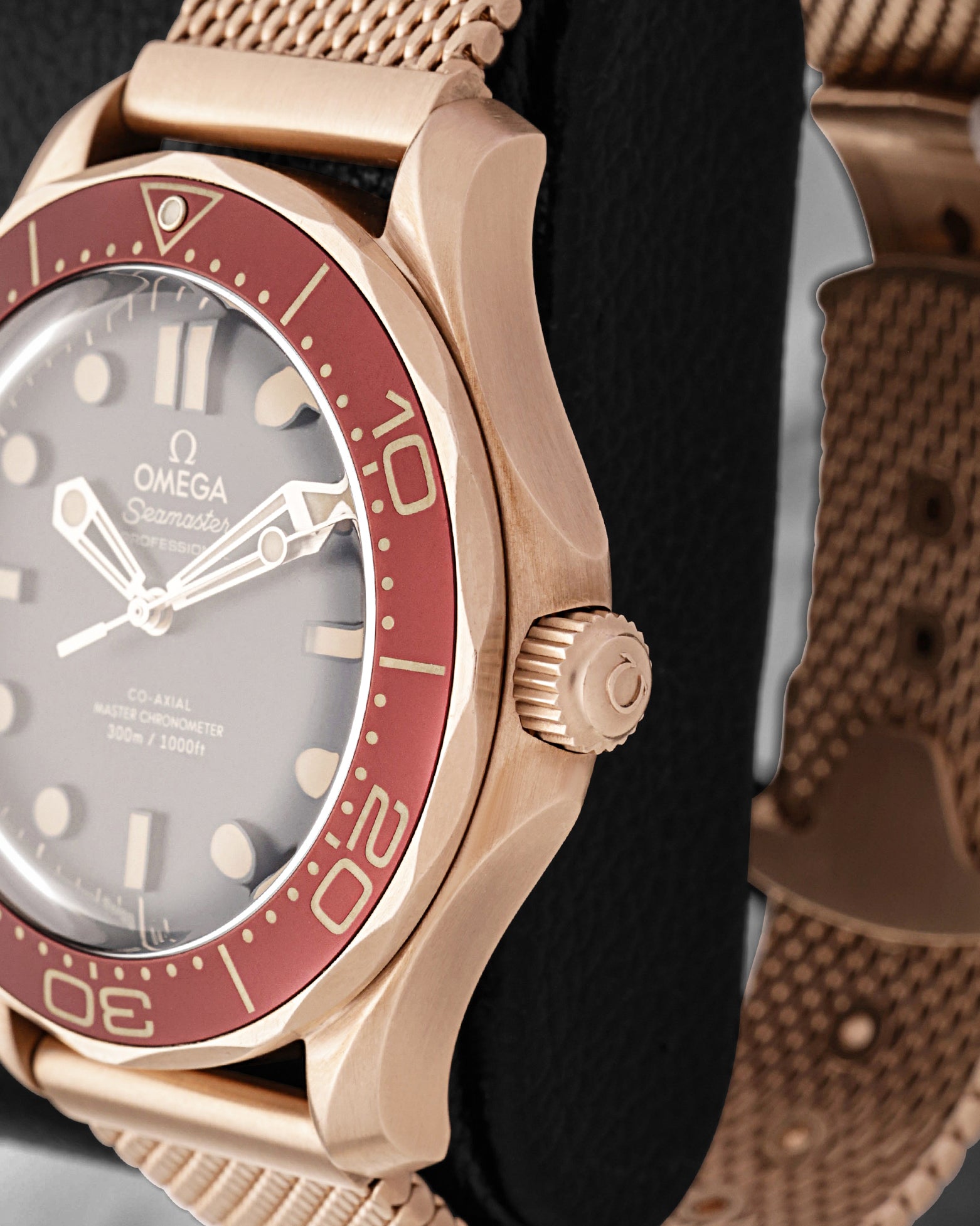 Close-up view of the screw-in crown and burgundy bezel on an Omega Seamaster Diver 300M