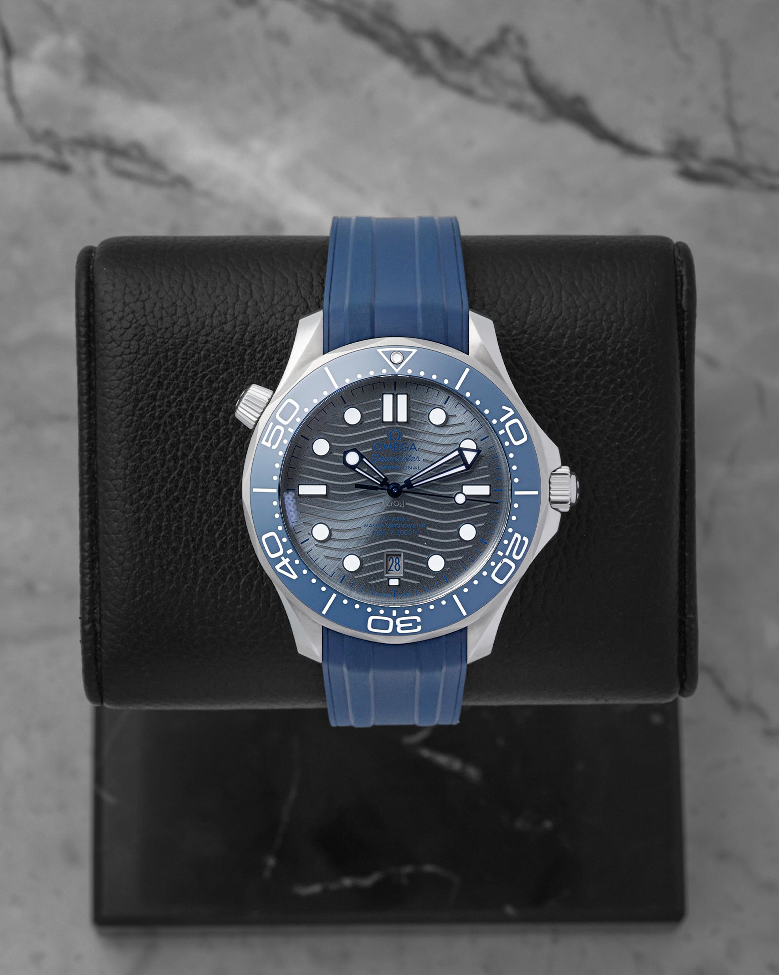 Omega Seamaster Diver 300M Co-Axial Master Chronometer 42mm watch with a grey wave dial and blue rubber strap, model 210.32.42.20.06.001, on display at Noah's Fine Watches & Jewelry in Dallas
