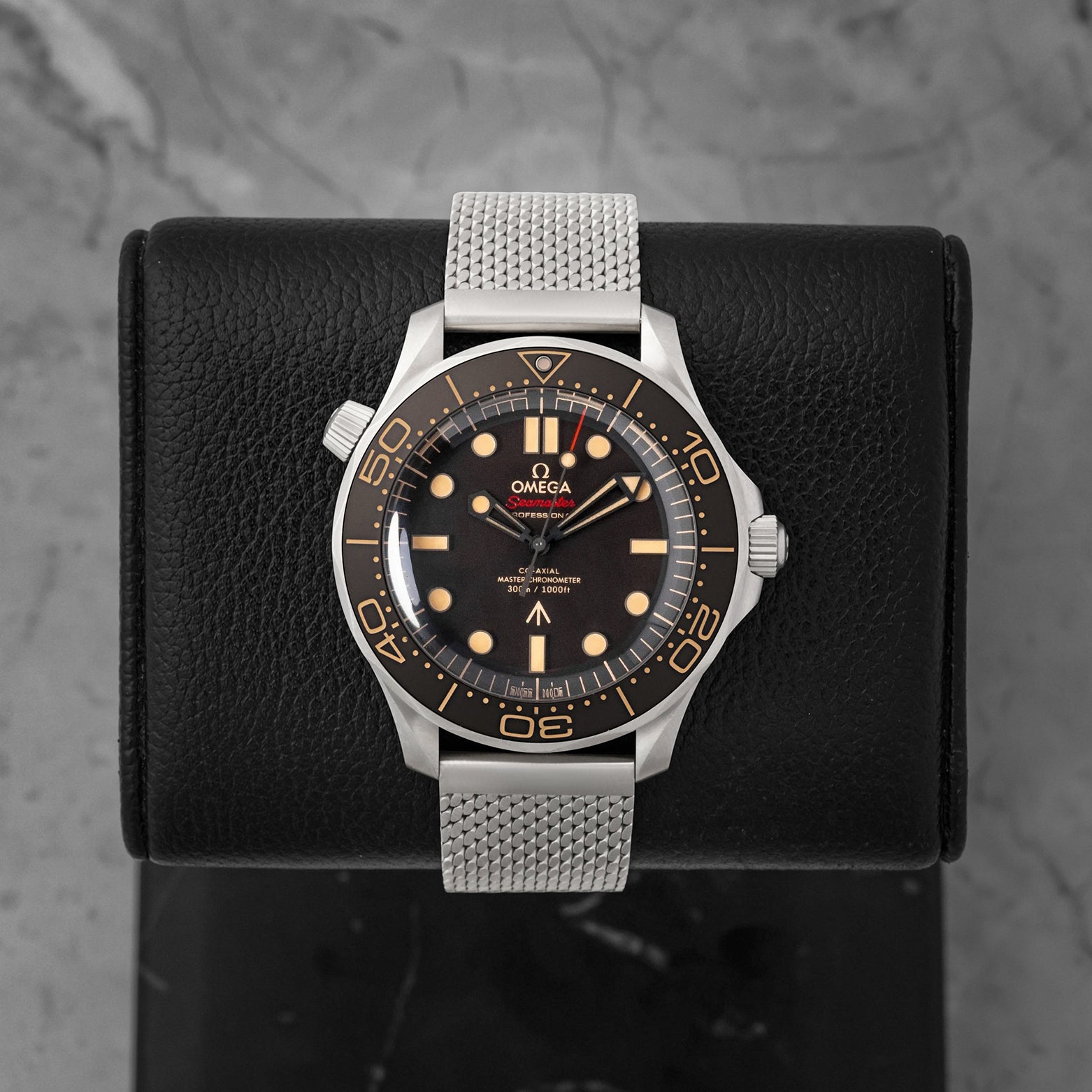 Front portrait view of a pre-owned Omega Seamaster Diver 300M No Time To Die 007 Edition titanium watch on a mesh bracelet, available at Noahs Fine Watches and Jewelry Dallas