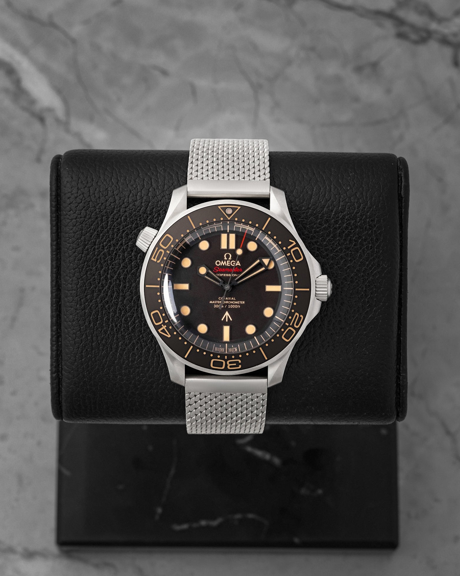 Front portrait view of a pre-owned Omega Seamaster Diver 300M No Time To Die 007 Edition titanium watch on a mesh bracelet, available at Noahs Fine Watches and Jewelry Dallas