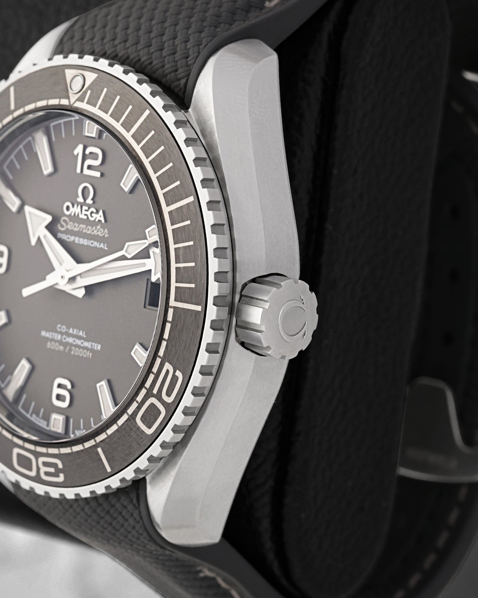 Close-up of the screw-down crown and coin-edge bezel on an Omega Seamaster Planet Ocean 600M