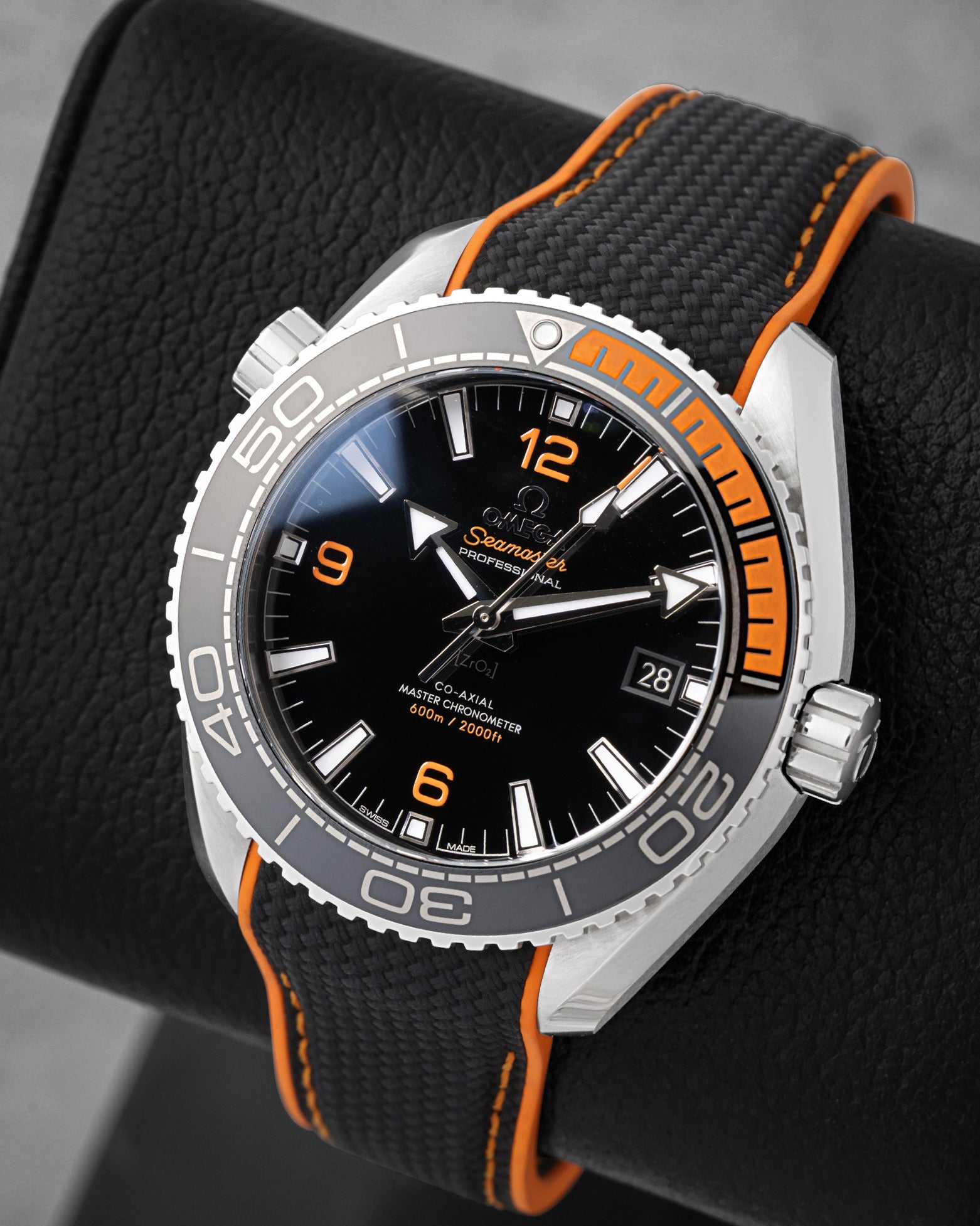 Angled view of Omega Seamaster Planet Ocean 600M black dial with orange Arabic numerals and bezel