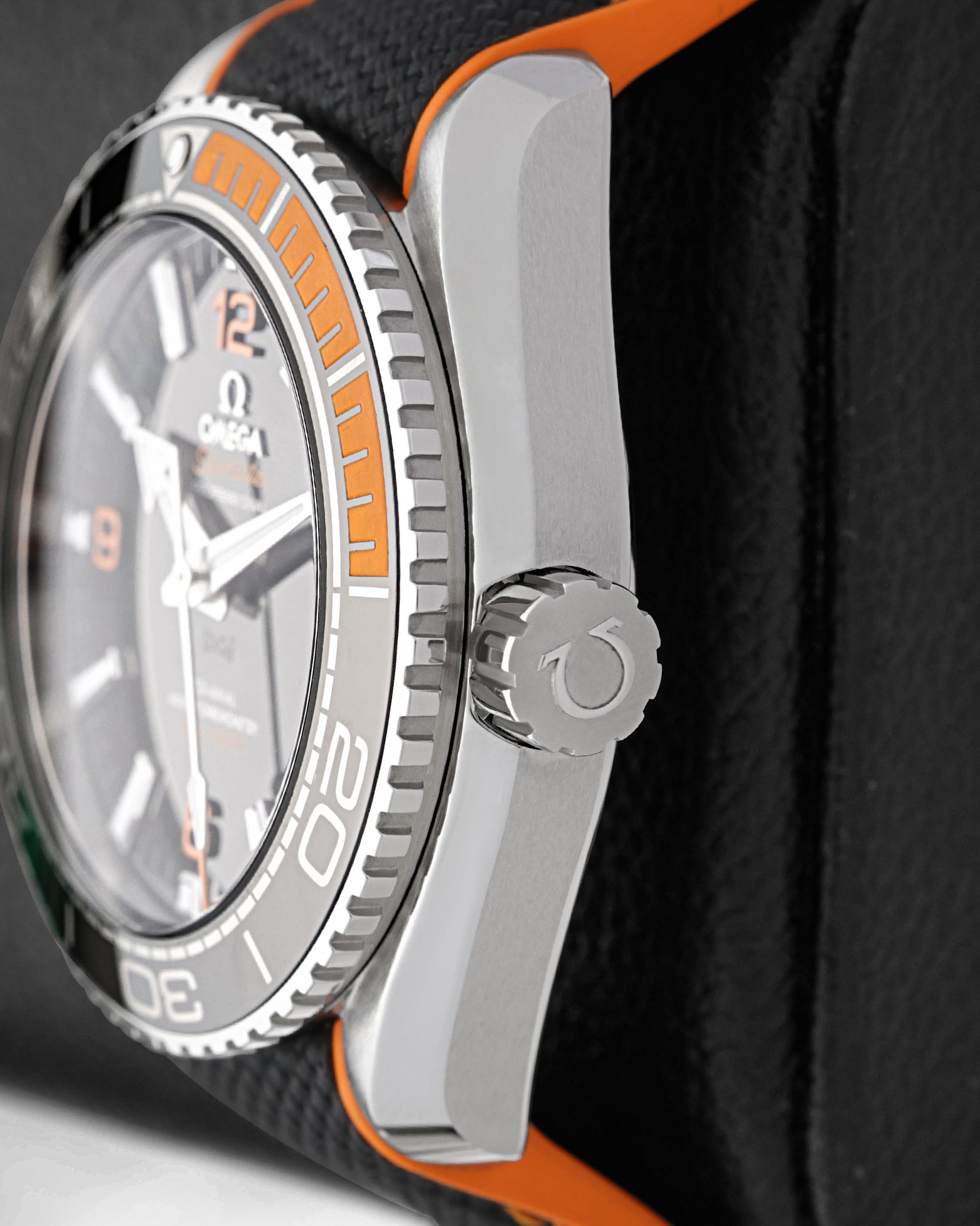 Close-up view of the screw-down crown and black ceramic bezel with orange rubber 15-minute diving scale