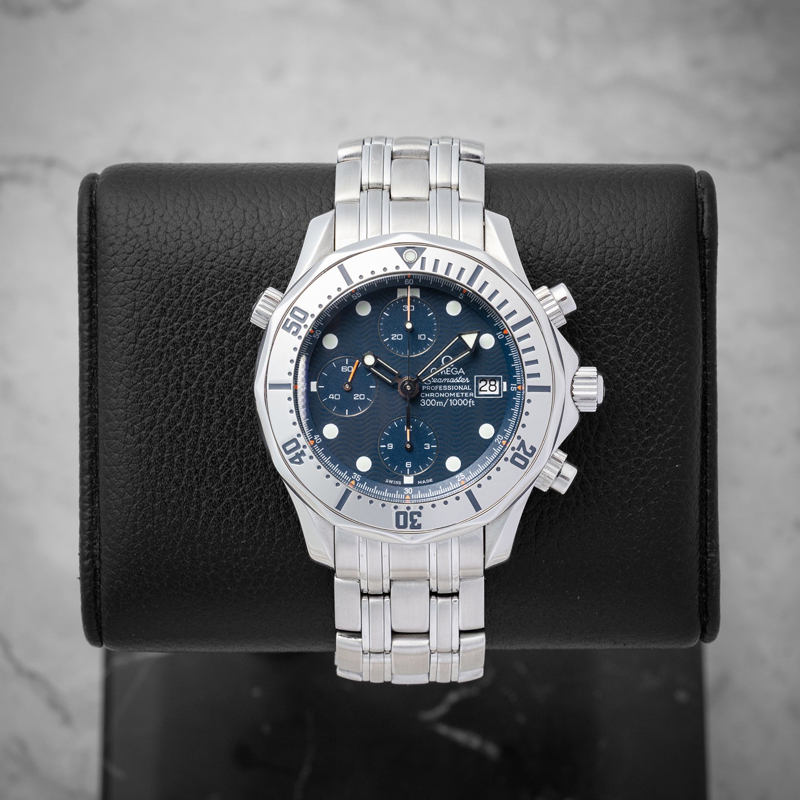 Omega Seamaster Professional 300M Chronograph 2598.80.00 with a blue wave dial and steel bezel mounted on a black display stand