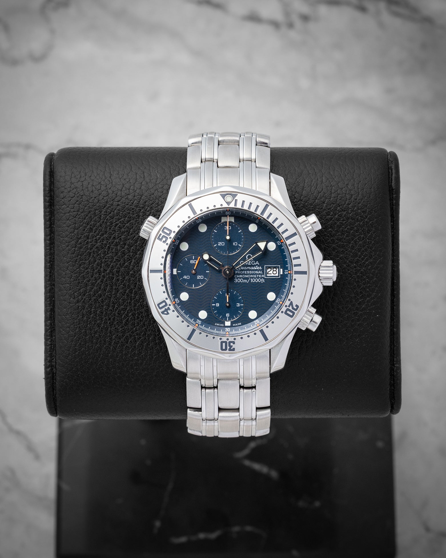Omega Seamaster Professional 300M Chronograph 2598.80.00 with a blue wave dial and steel bezel mounted on a black display stand