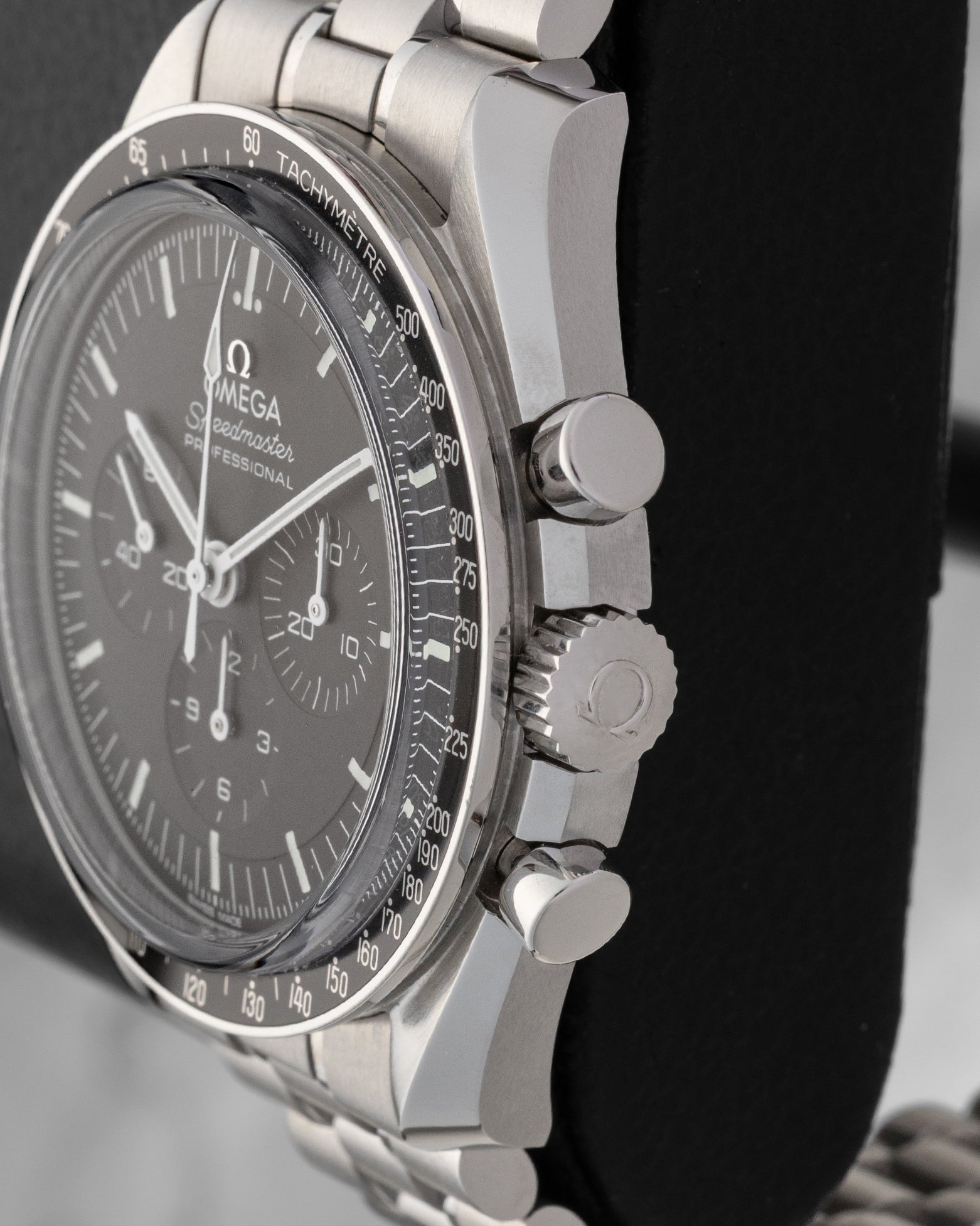 Side profile view showing the stainless steel case, winding crown, and chronograph pushers on Omega Speedmaster Moonwatch 310.30.42.50.01.002