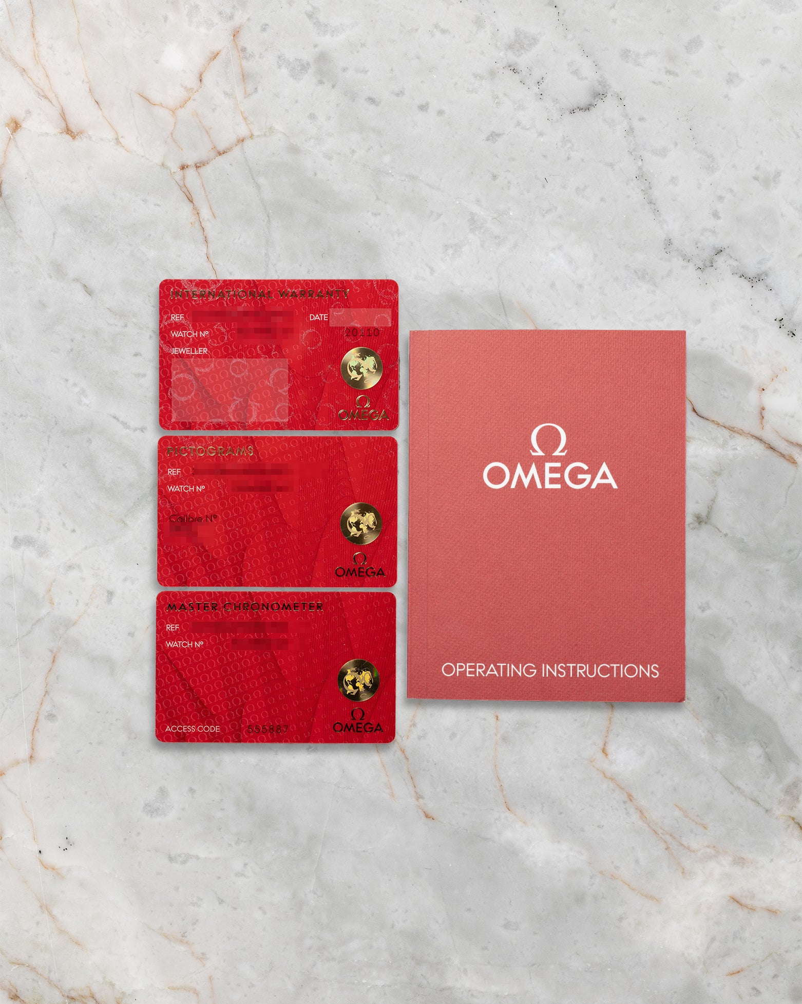 Original red Omega international warranty card set, pictograms, Master Chronometer card, and manual included with Speedmaster 310.30.42.50.01.002