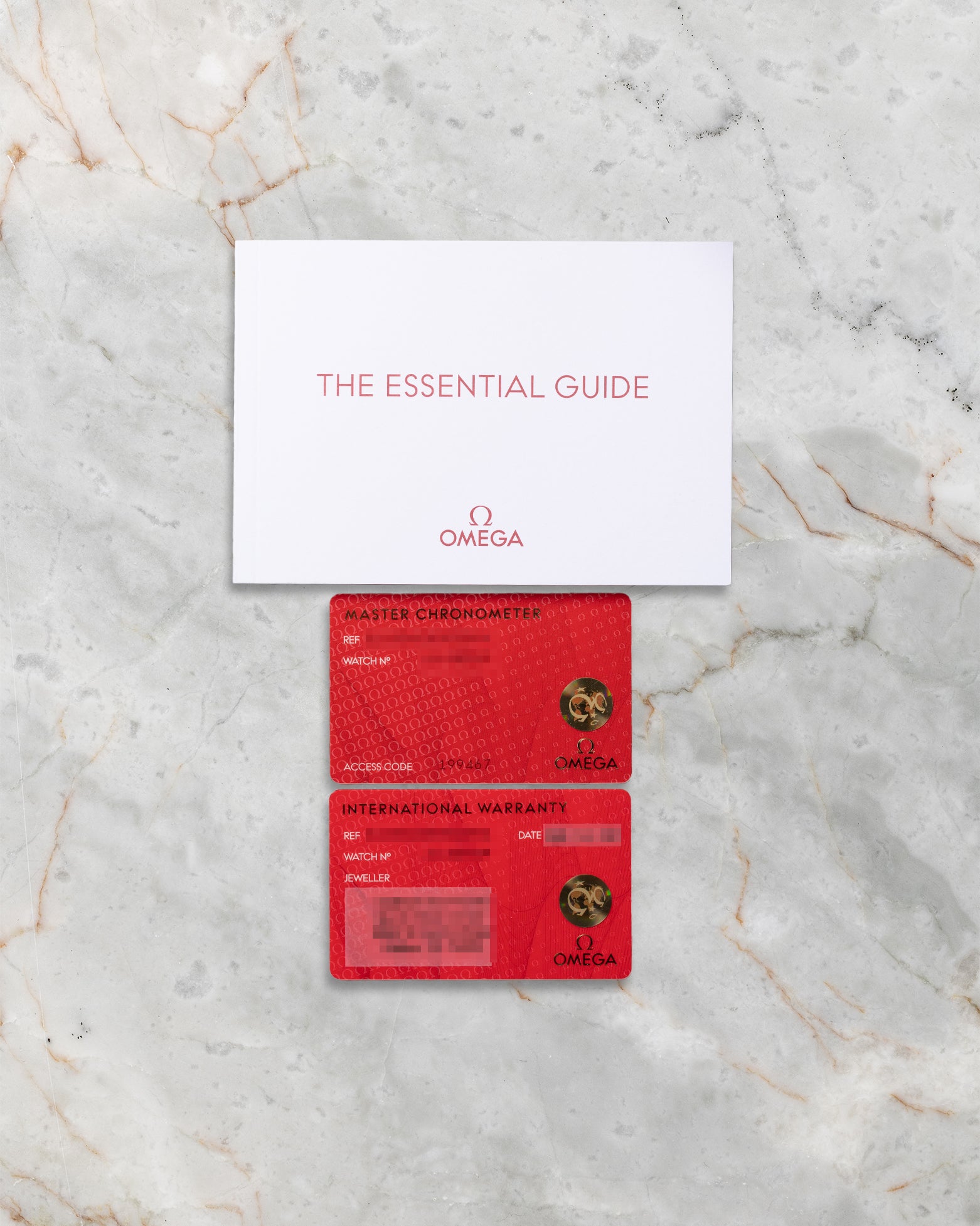 Original red Omega international warranty cards and Essential Guide booklet included with Speedmaster Reverse Panda 310.30.42.50.01.004