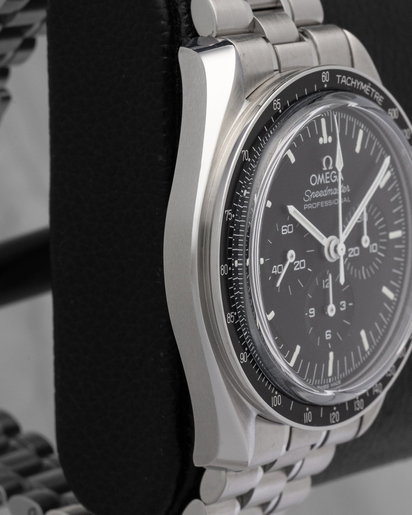 Left-side macro profile view capturing the distinctive satin-brushed caseband flank and the iconic twisted lyre sports lugs flowing into a tapered steel link band