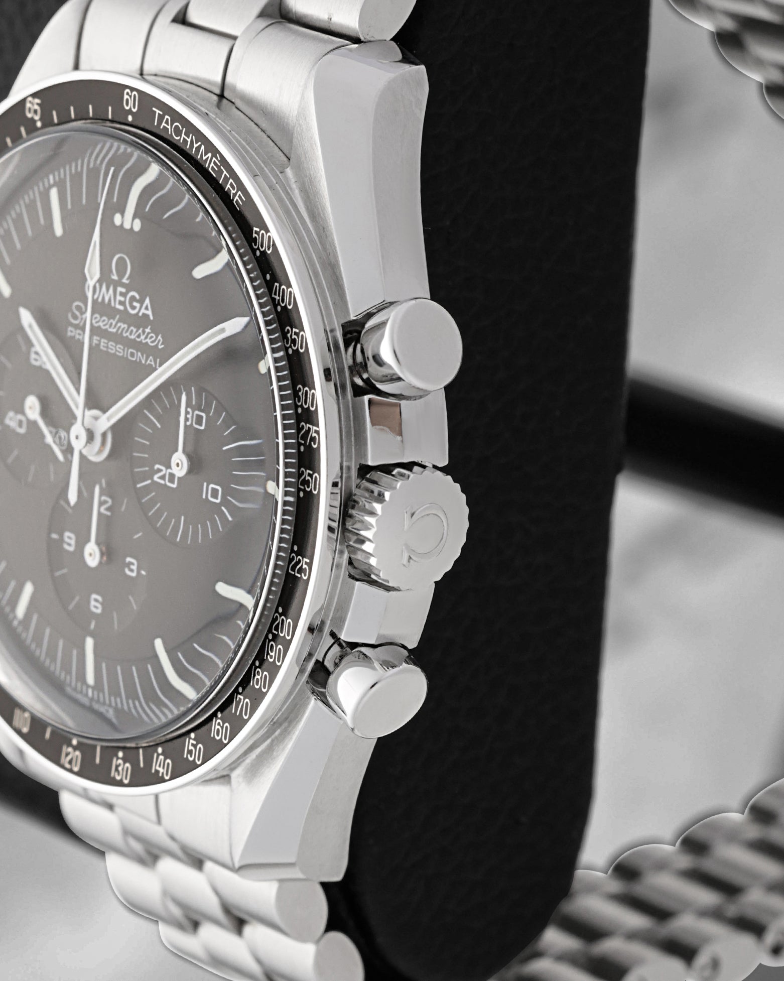 Close-up of the winding crown and tactile chronograph pushers on an Omega Speedmaster Hesalite