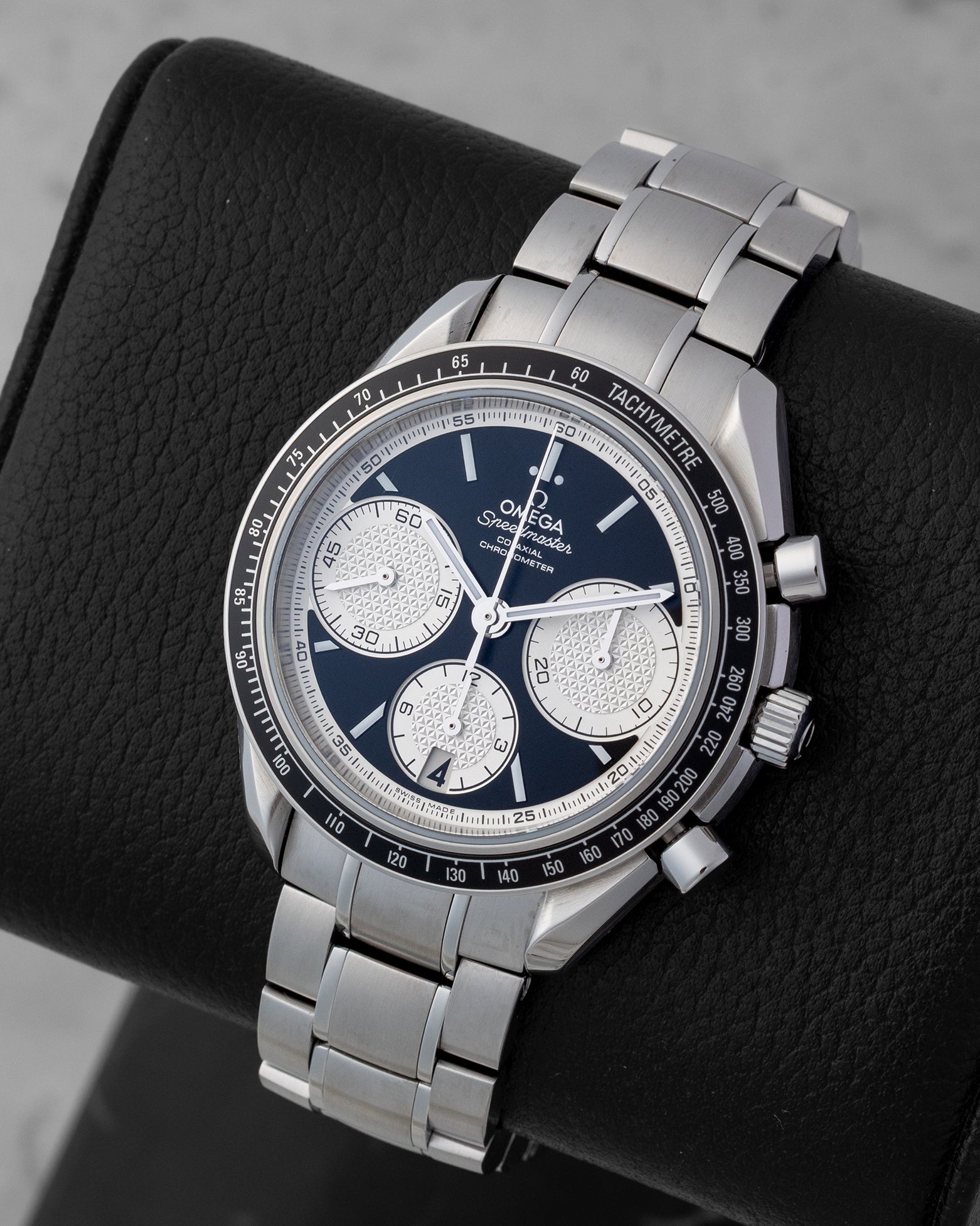 Angled view of Omega Speedmaster 326.30.40.50.01.002 showing black dial, textured white Clous de Paris sub-dials, and tachymeter bezel