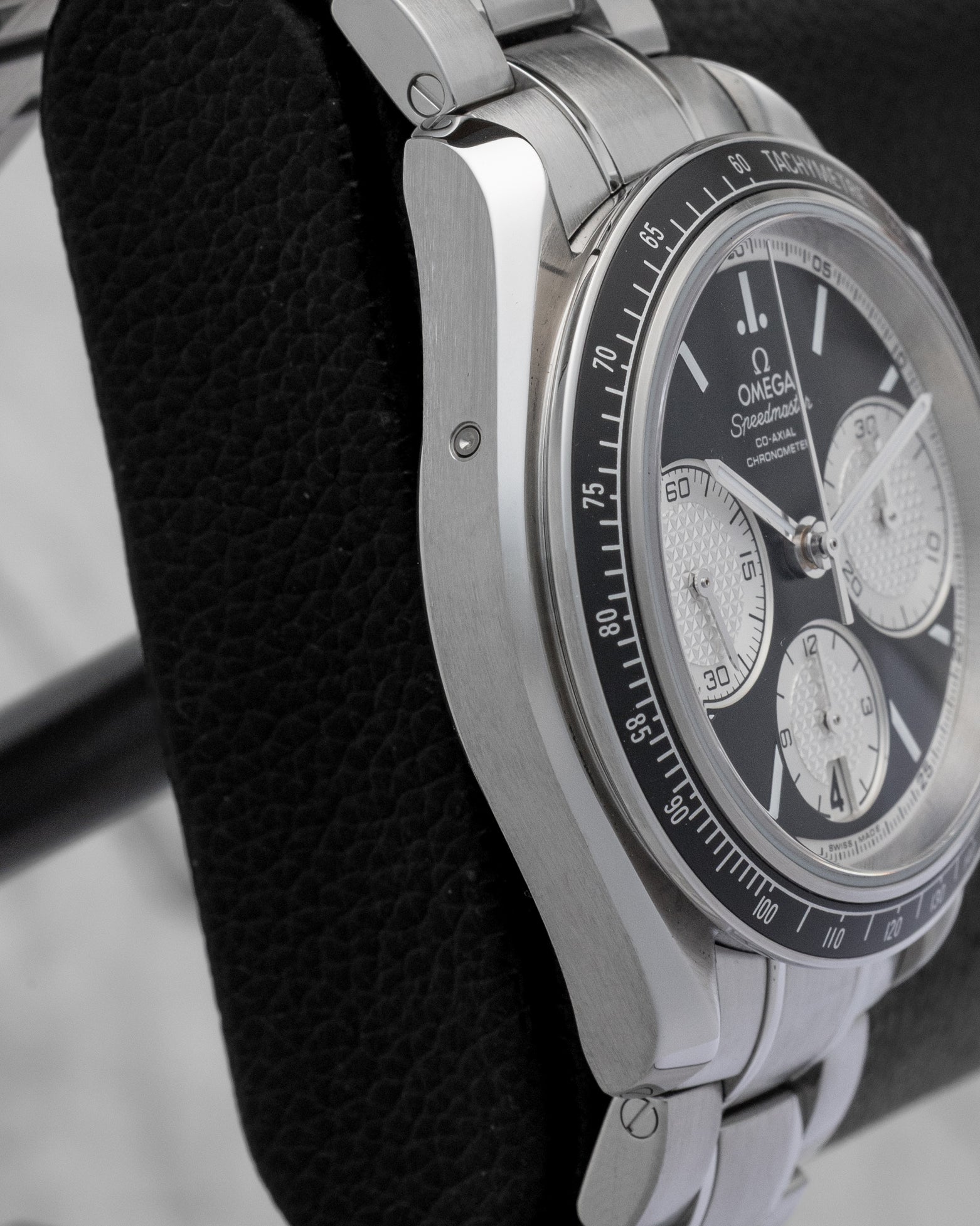 Stainless steel case side profile showing the 10 o'clock quick date corrector button on Omega Speedmaster Racing 40mm