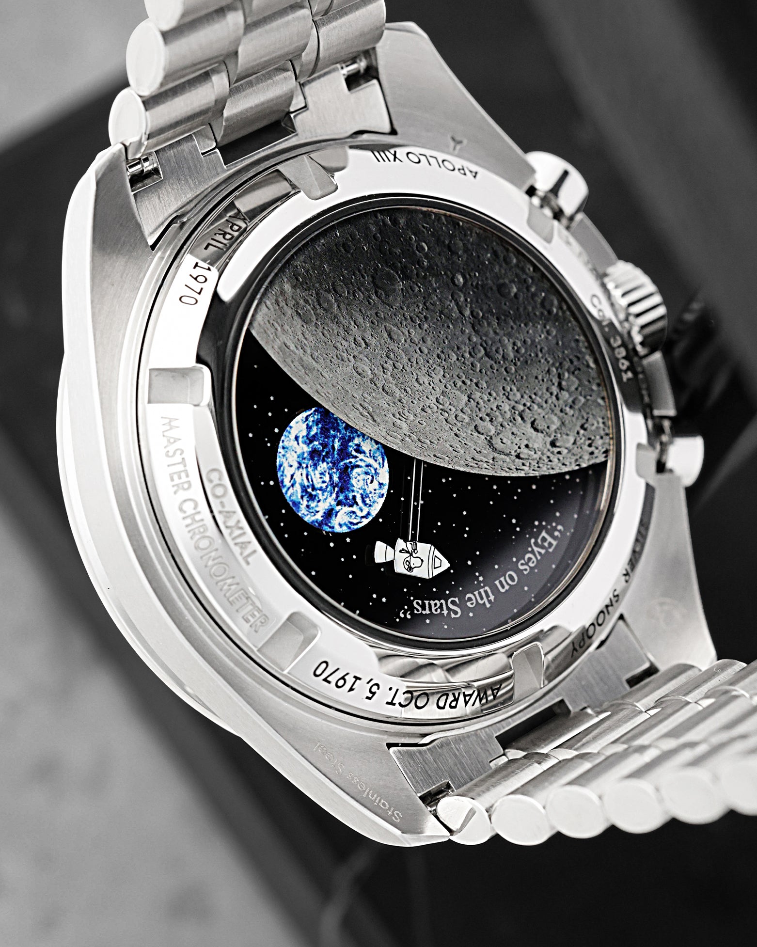 Detailed sapphire case back view featuring animated Snoopy in Command Module, rotating Earth disc, and lunar surface on Omega Speedmaster