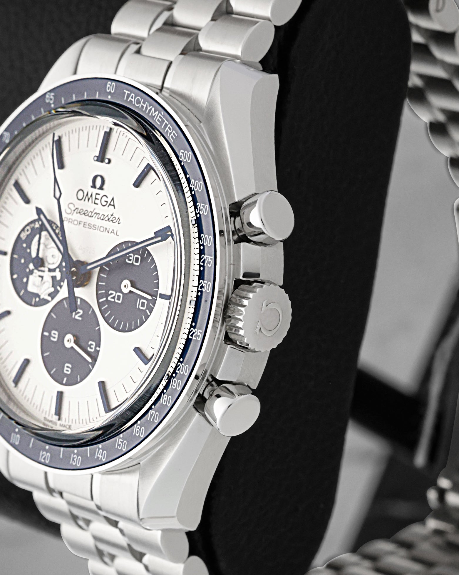 Side view close-up of the crown, chronograph pushers, and blue ceramic tachymeter bezel on Omega Speedmaster Snoopy 50th Anniversary