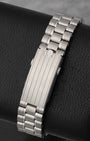 A rear view of the five-row stainless steel bracelet focusing on the brushed folding deployment buckle detailed with polished stripes and an embossed Omega emblem