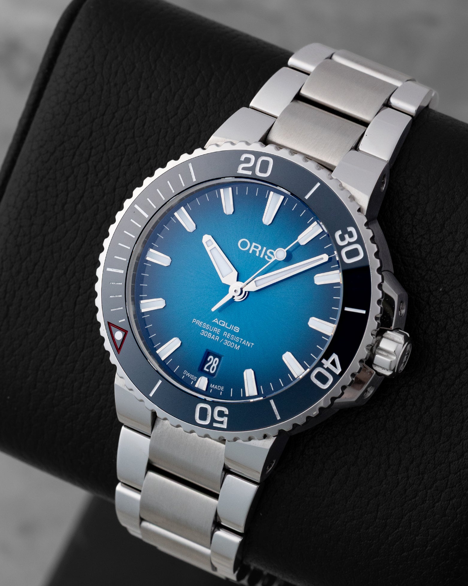 Angled shot of a pre-owned 2022 Oris Aquis Clean Ocean Limited Edition 39.5mm dive watch showing the teal dial and stainless steel multi-link bracelet.