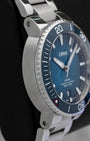 Left side profile view highlighting the stainless steel case and aqua blue ceramic dive bezel insert on the pre-owned 2022 Oris Clean Ocean.