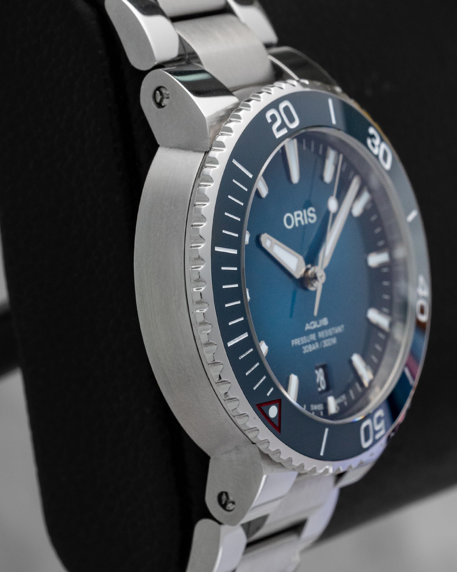 Left side profile view highlighting the stainless steel case and aqua blue ceramic dive bezel insert on the pre-owned 2022 Oris Clean Ocean.