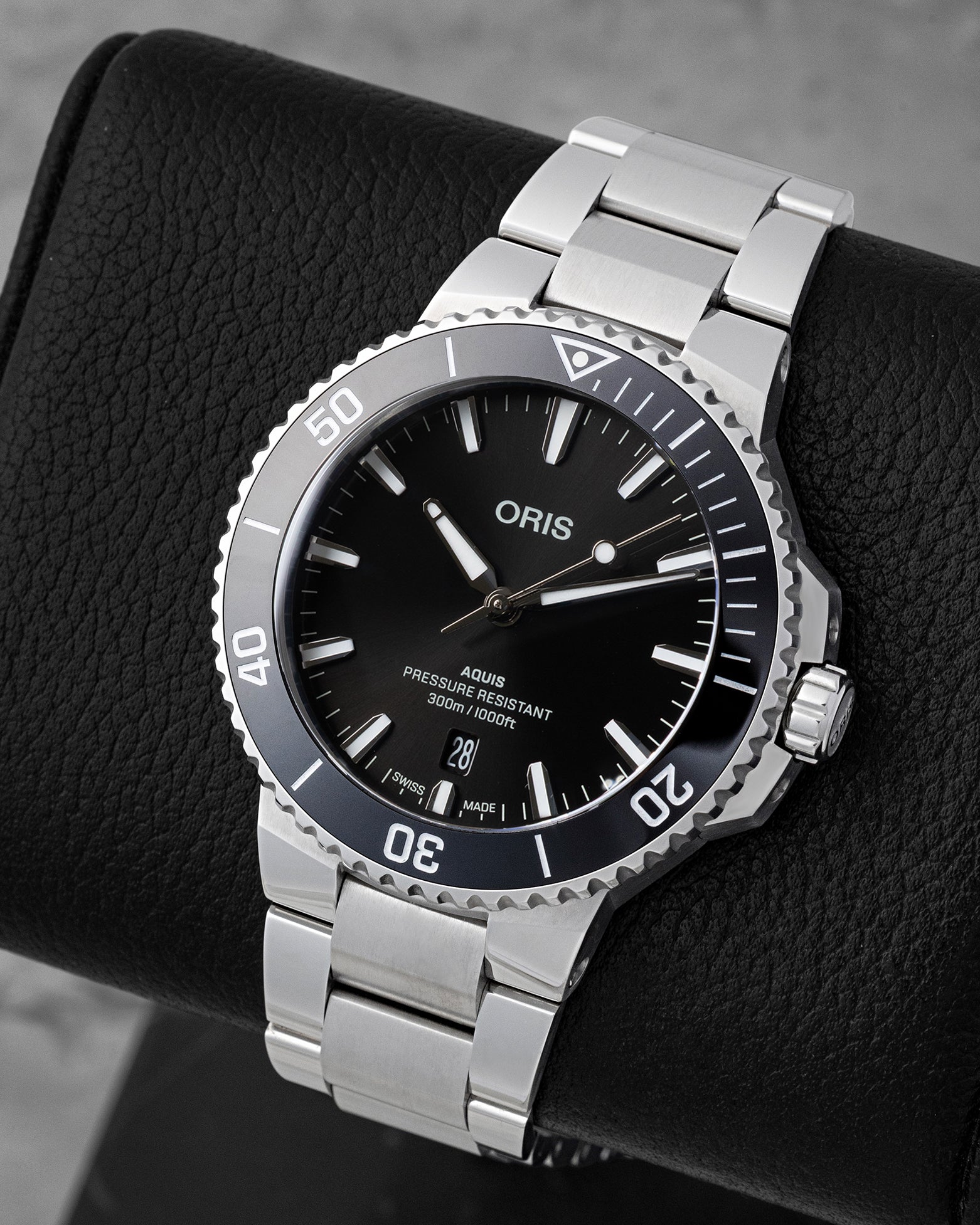 Angled view of 41.5mm Oris Aquis Date showing black sunray dial, luminous indices, and black ceramic bezel