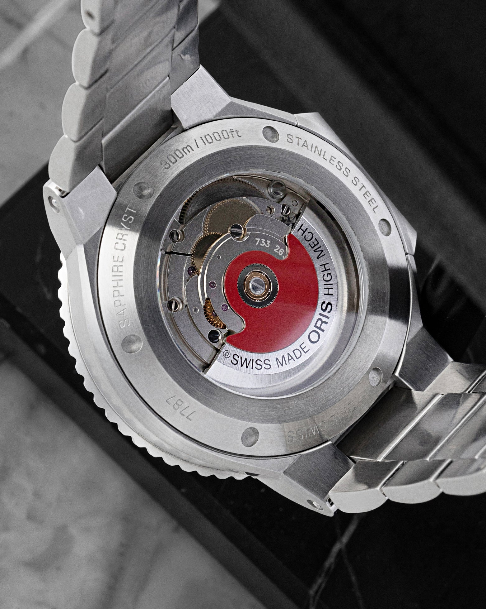 Exhibition mineral glass caseback displaying the signature red rotor on Calibre Oris 733 automatic movement