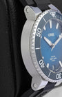 Left profile view of the satin-brushed watch case lugs and the polished knurled edge of a blue Oris diver bezel
