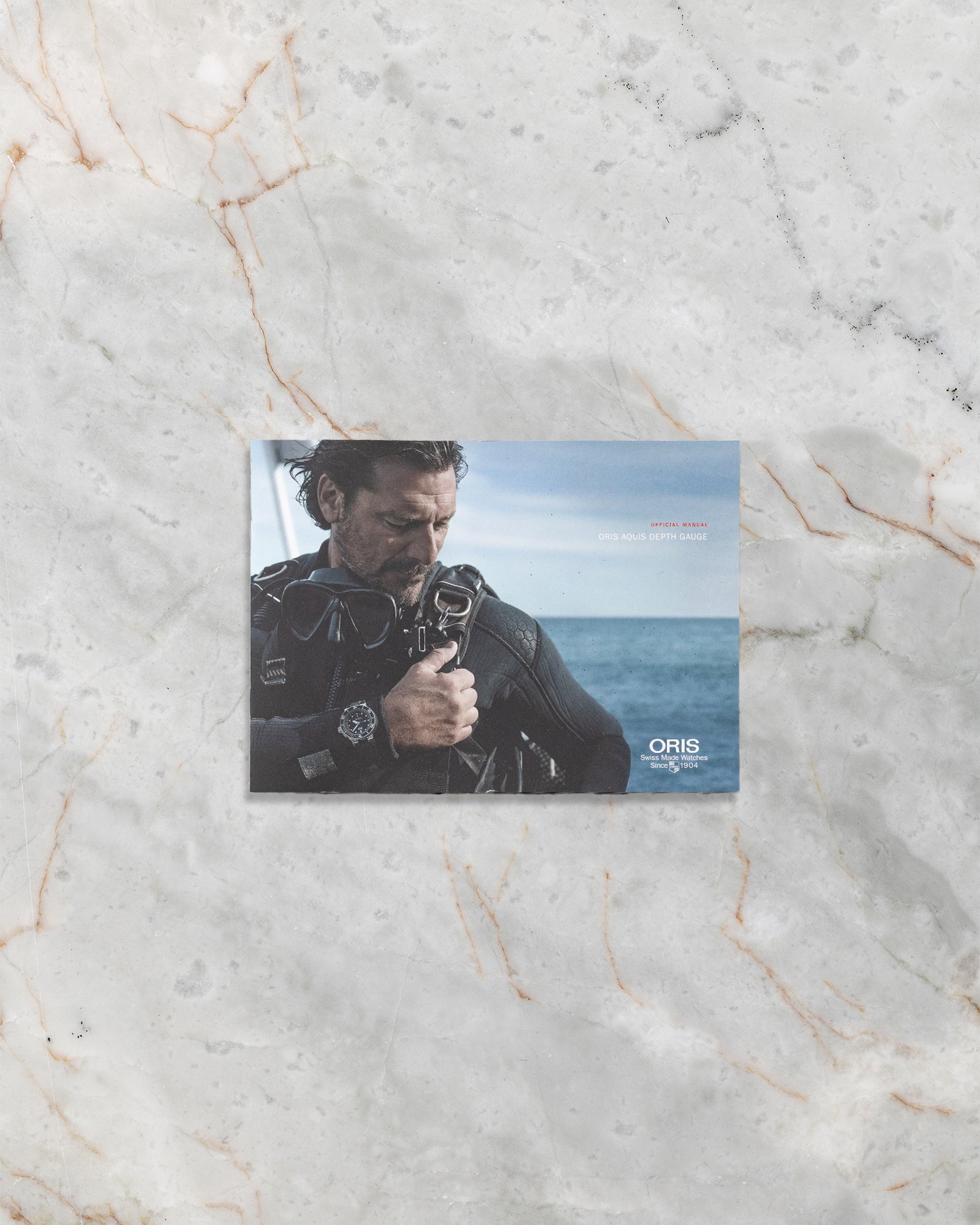 Official Oris Aquis Depth Gauge instruction booklet and warranty card documentation.