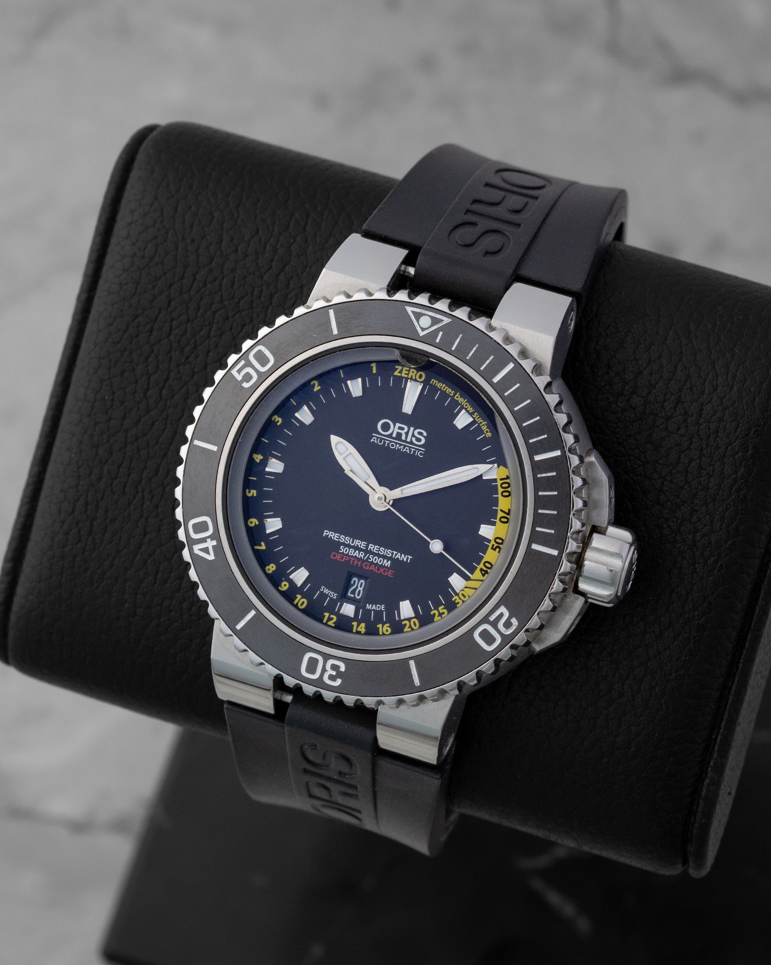 Angled perspective of a pre-owned Oris Aquis Depth Gauge 46mm dive watch showing the ceramic bezel, depth gauge sapphire crystal, and black rubber strap.