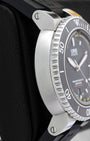 Left side profile view highlighting the thick stainless steel case, sapphire crystal depth entry hole, and knurled ceramic dive bezel.