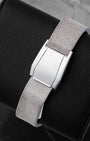 Close-up of the green textile linen strap and custom stainless steel seatbelt-style folding clasp on an Oris watch