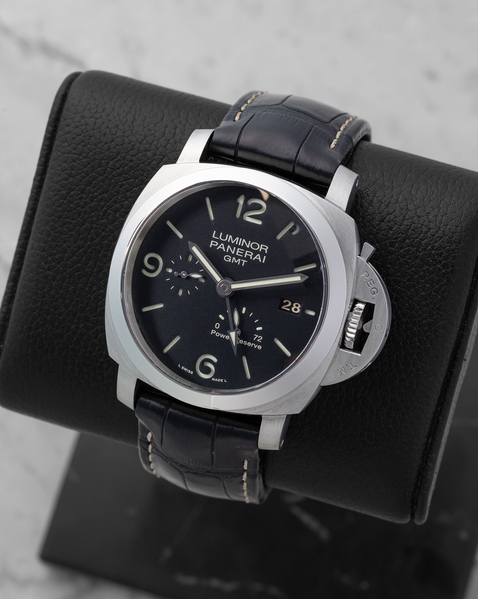 Angled front view of a preowned 2011 Panerai Luminor 1950 GMT PAM00321 featuring a black sandwich dial, date display, GMT hand, and power reserve indicator