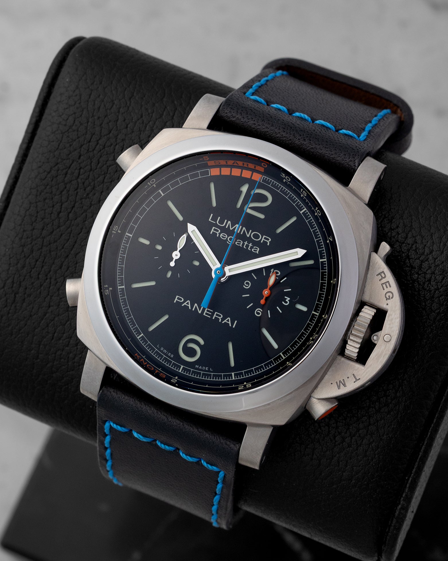 Angled view of Panerai PAM00526 displaying black dial, regatta countdown scale, orange and blue hands, and titanium case