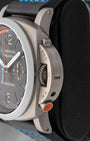 Side profile view showing brushed titanium crown guard and orange regatta countdown pusher at 4 o'clock on Panerai PAM00526