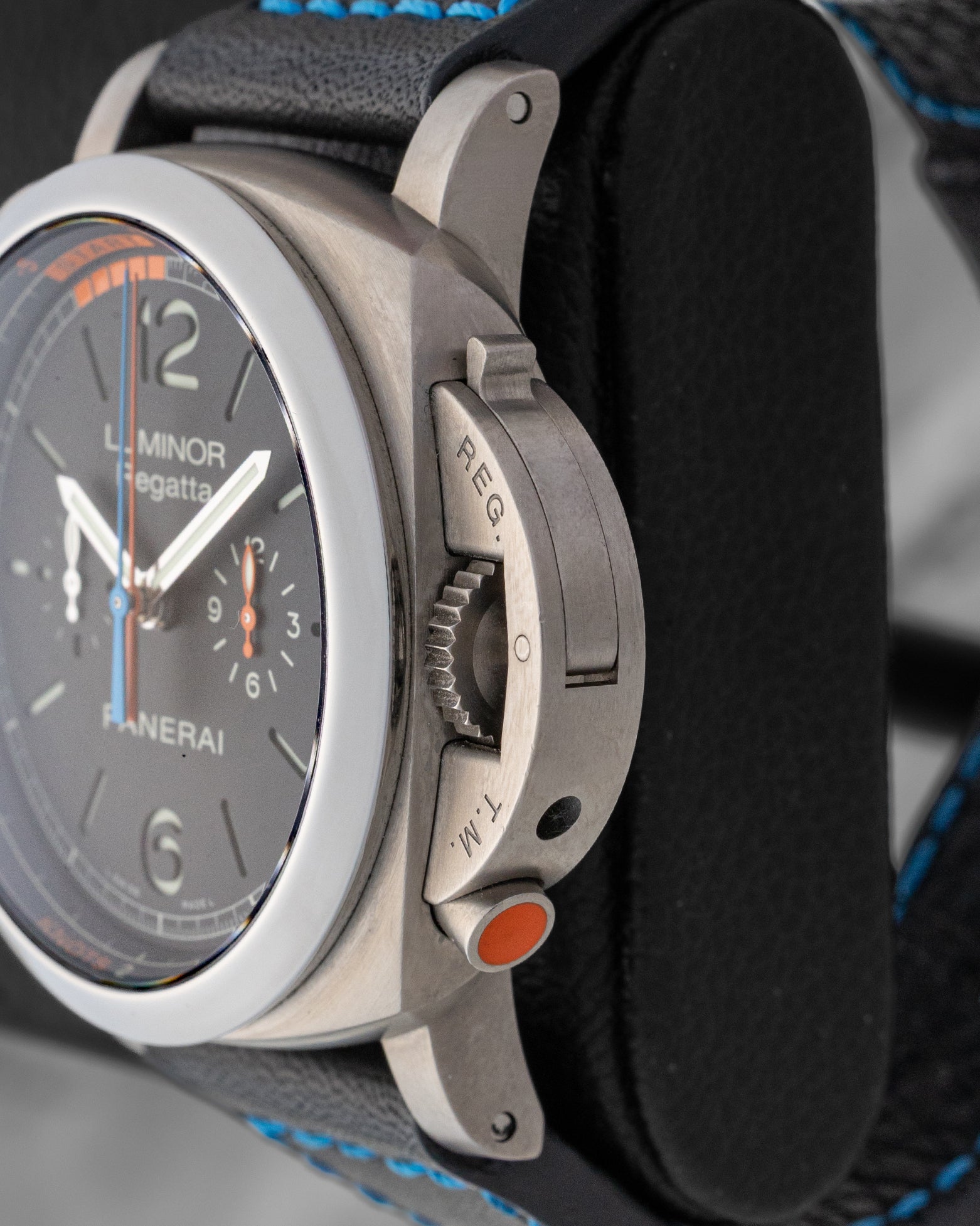 Side profile view showing brushed titanium crown guard and orange regatta countdown pusher at 4 o'clock on Panerai PAM00526
