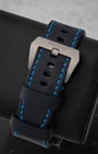 Black leather watch strap with blue contrast stitching and brushed titanium pin buckle on Panerai PAM00526