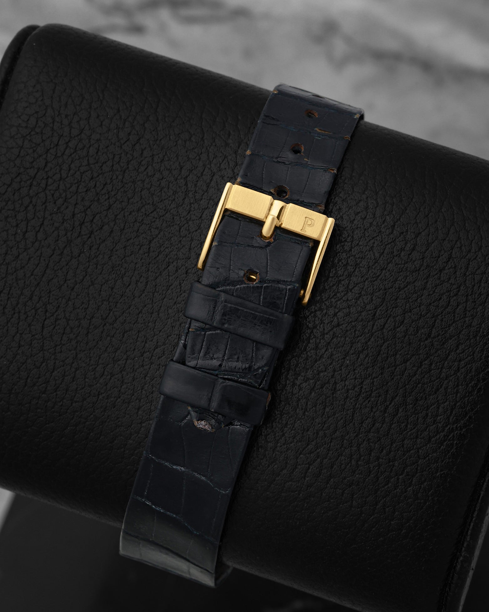 Close-up of the premium blue alligator leather watch strap and matching 18k yellow gold tang buckle