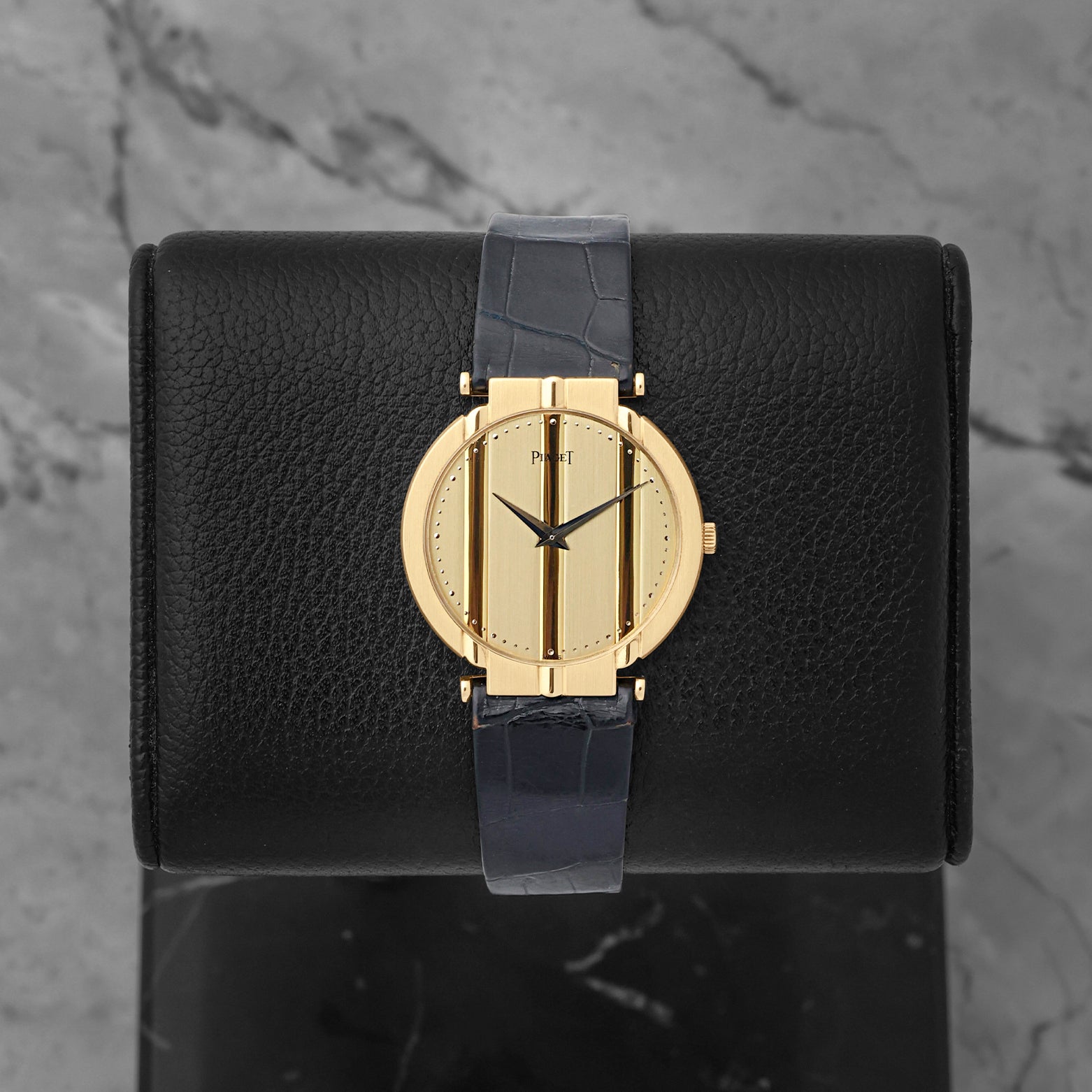 Vintage Piaget Polo 18k yellow gold watch with a striped gold dial, reference 8673, on a blue alligator leather strap at Noah's Fine Watches & Jewelry in Dallas