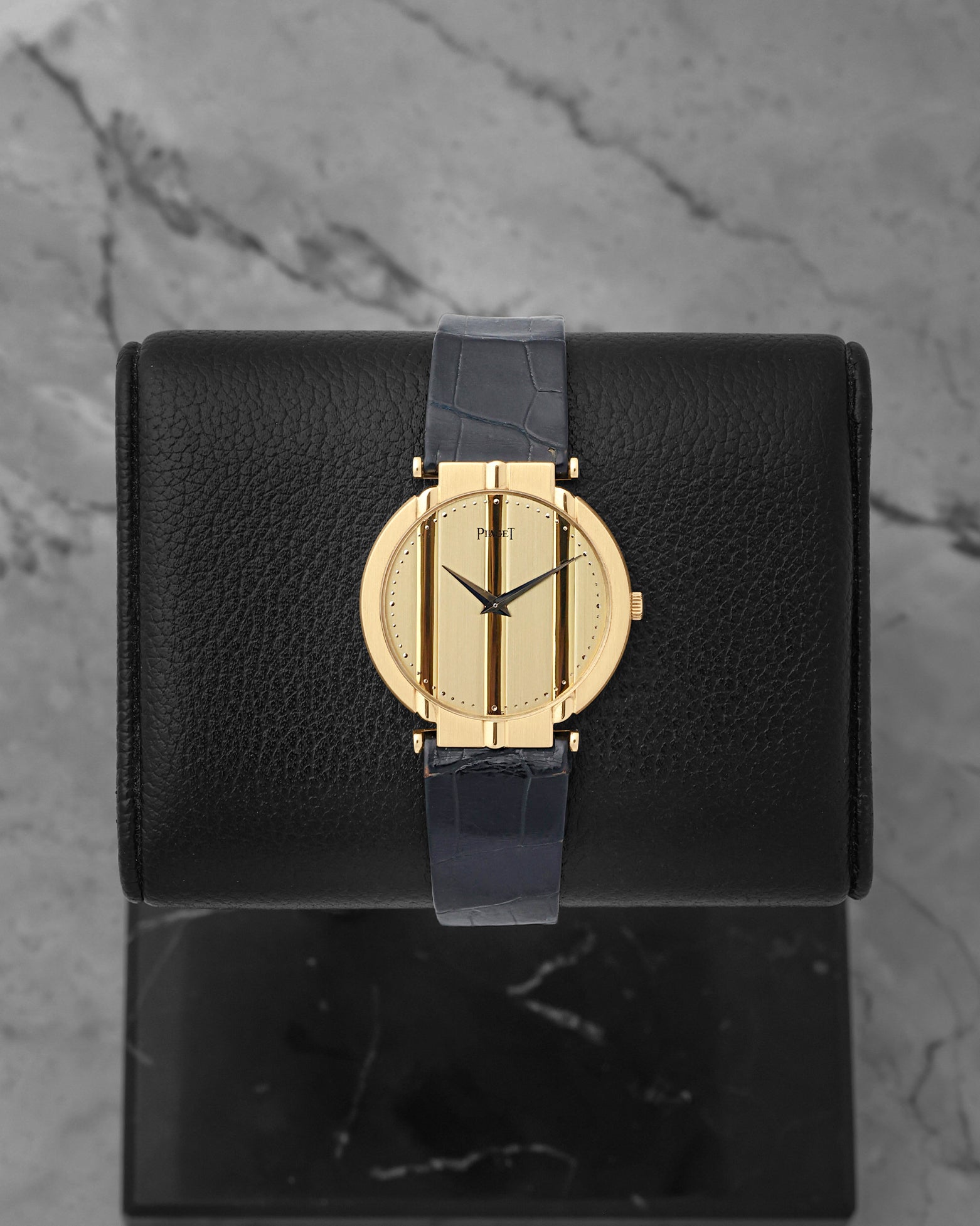 Vintage Piaget Polo 18k yellow gold watch with a striped gold dial, reference 8673, on a blue alligator leather strap at Noah's Fine Watches & Jewelry in Dallas