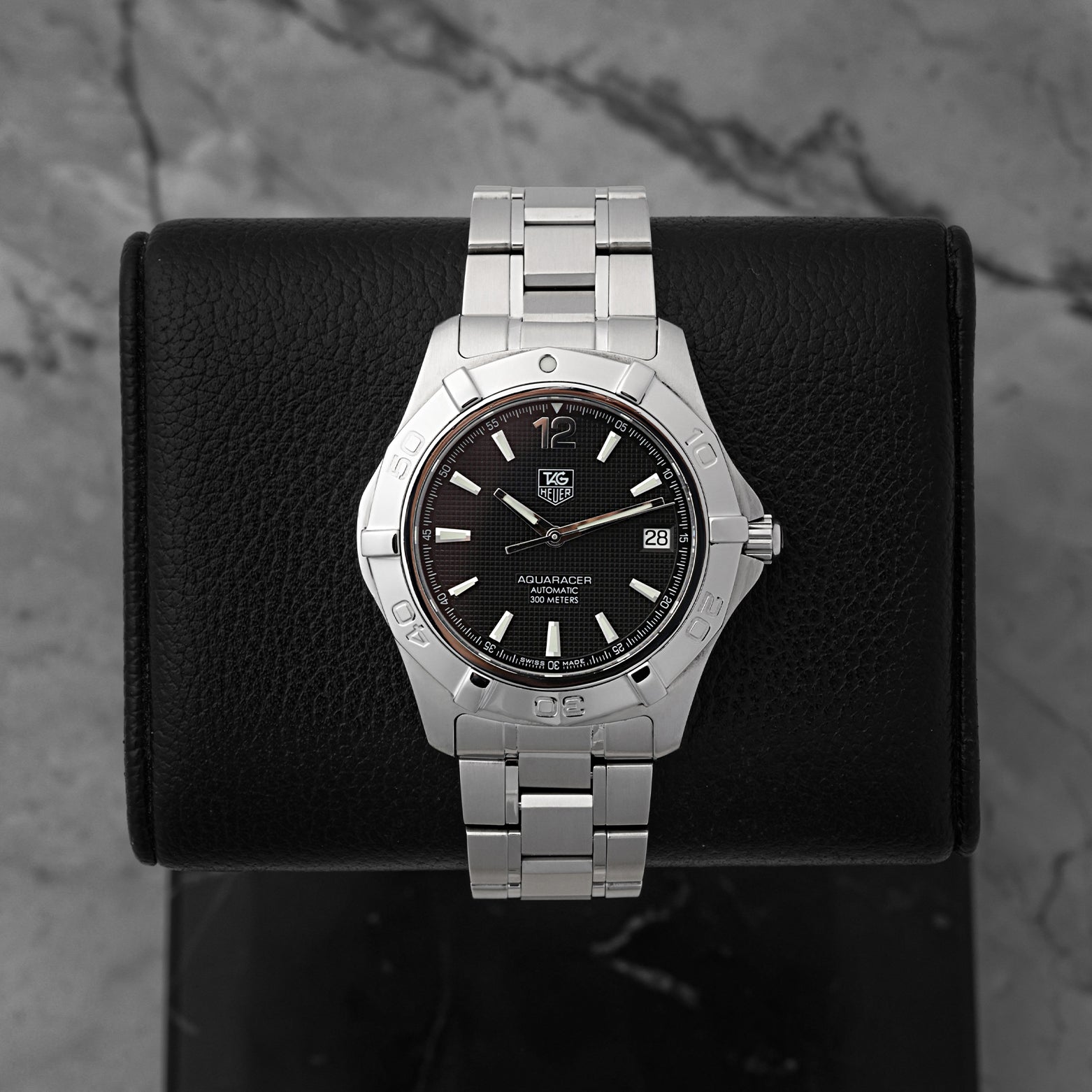 preowned 2006 TAG Heuer Aquaracer 300M reference WAF2110 showcasing its matte charcoal black dial, luminescent stick markers, and signature Arabic numeral 12 index at Noah's Fine Watches & Jewelry in Dallas
