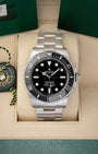 A pre-owned 2024 Rolex Submariner No-Date reference 124060 featuring a symmetrical glossy black dial, Chromalight maxi display, and black ceramic Cerachrom bezel insert inside its box at Noah's Fine Watches & Jewelry in Dallas