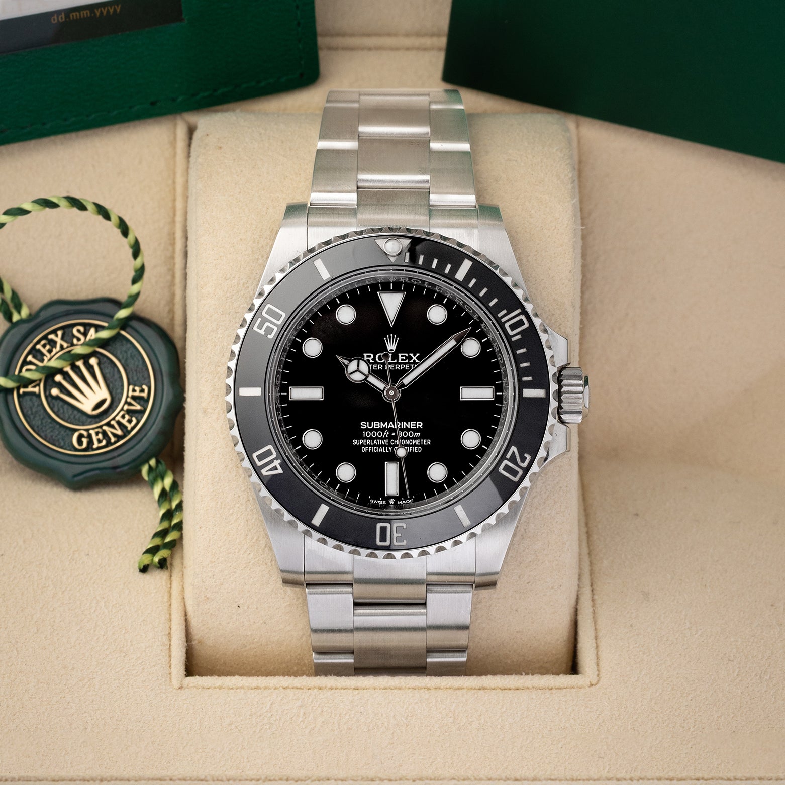 A pre-owned 2024 Rolex Submariner No-Date reference 124060 featuring a symmetrical glossy black dial, Chromalight maxi display, and black ceramic Cerachrom bezel insert inside its box at Noah's Fine Watches & Jewelry in Dallas