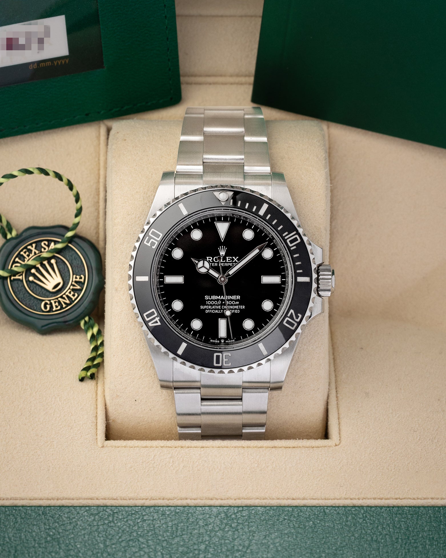 A pre-owned 2024 Rolex Submariner No-Date reference 124060 featuring a symmetrical glossy black dial, Chromalight maxi display, and black ceramic Cerachrom bezel insert inside its box at Noah's Fine Watches & Jewelry in Dallas